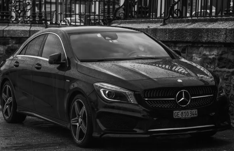 Gros plan sur la face avant d'un utilitaire Mercedes Sprinter blanc stationné à côté de matériel d'artisan